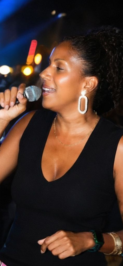 Esther au micro, robe noire, lumières de scène